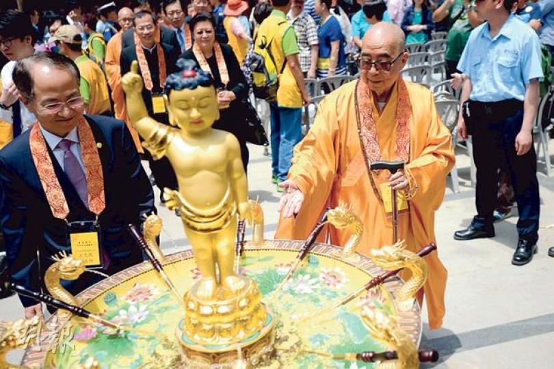 寶蓮禪寺住持釋智慧（右前）昨主持浴佛慶典，慶典期間他要使用拐杖，他自言近年身體狀况欠佳，寺內一切實務已交由首座和尚釋健釗負責，並形容自己是「看門工」。（葉家豪攝）寶蓮禪寺一連8日舉行公眾浴佛，圖右建築物為即將竣工的萬佛殿，預計今年10月31日開光，萬佛殿樓高5層，此項目經政府漫長考慮破例允許興建。 （葉家豪攝）