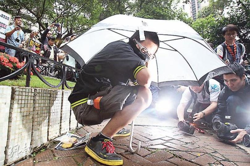 10多名不滿蘇錦樑「包容論」嘅網民噚日去蘇錦樑寓所門前抗議,有網民預備咗番薯同花泥做嘅「糞便」,踎喺地上扮如廁,要求蘇局長「包容」佢哋嘅行為。(林俊源攝) 10多名不滿蘇錦樑「包容論」嘅網民噚日去蘇錦樑寓所門前抗議,有網民預備咗番薯同花泥做嘅「糞便」,踎喺地上扮如廁,要求蘇局長「包容」佢哋嘅行為。(林俊源攝)