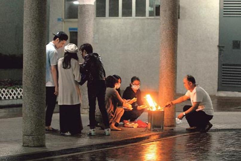 被警員開槍擊斃男子何世通的妻子(右二)及一眾死者親友,昨凌晨帶同何生前衣服及一堆紙錢,重返現場對開拜祭,其間各人神情哀傷,逗留約半小時後才離去。(伍浦鋒攝) 被警員開槍擊斃男子何世通的妻子(右二)及一眾死者親友,昨凌晨帶同何生前衣服及一堆紙錢,重返現場對開拜祭,其間各人神情哀傷,逗留約半小時後才離去。(伍浦鋒攝)