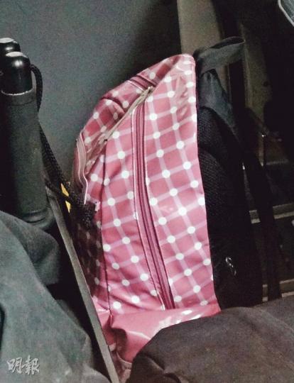 12歲跳樓女生在所住大廈的天台留下粉紅色書包（圖）及手機。（林智傑攝）死者兄長（左）事後由警員陪同，趕到仁濟醫院了解情况。（林智傑攝）