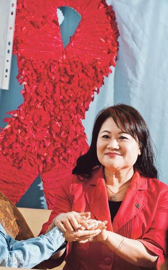 愛滋寧養服務協會行政總監陳麗卿（右）指出，協會提供的「預防母嬰感染計劃」至今有30名愛滋病母親受惠，不但會為孕婦提供藥物督導及情緒輔導，亦會在嬰兒出生後兩年繼續跟進。圖左伸出右手者為不欲出鏡、患有愛滋病的媽媽阿玲。（劉焌陶攝）