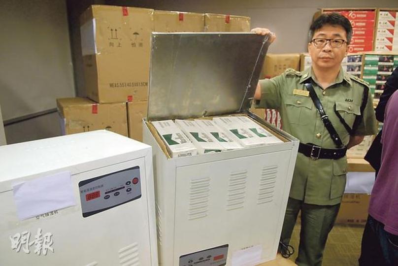海關發現「抽濕機」外表簡陋，甚至配有內地的兩腳插頭，不適合香港使用，起疑下撬開外殼發現零件已被掏空，內藏70盒私煙。（伍浦鋒攝）