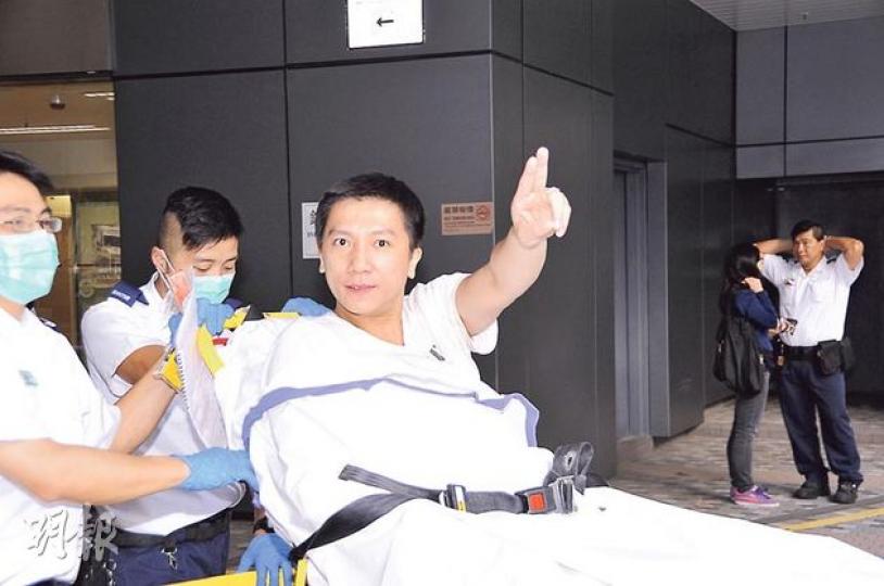「藥駕男」轉院時風騷地舉起手指，疑似舞劍地高呼：「去大埔醫院再影過，影得我靚仔啲！」（丁灝嵐攝）在大圍涉嫌藥駕的男子，其座駕內放有多尊佛像及擺設。（蔡方山攝）涉嫌藥駕被捕事主企圖以陰司紙支付雞粥及乳鴿錢，事敗後將陰司紙撒於地上。（蔡方山攝）