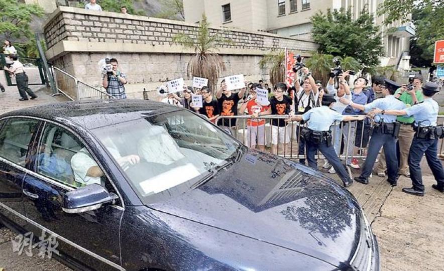 教育局長吳克儉出席活動後乘座駕離開，警方沿路架起鐵馬，防止示威的學民思潮成員衝出攔截吳的座駕。（鄧宗弘攝）教育局長吳克儉（中）昨出席賽馬會美荷樓香港精神學習計劃啓動禮，學民思潮則在場外示威，要求吳收回有關佔中的言論，吳並無回應。圖左為資深教育工作者黃浩潮，右為歷史學者丁新豹。（鄧宗弘攝）
