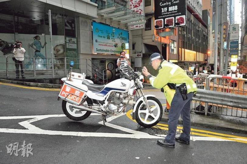 被休班見習督察騎着衝落斜路後翻倒的警察鐵馬，事後被扶正，車身輕微刮花，警方其後在場拍照記錄。（蔡方山攝）被補休班見習督察龐運龍（左）在警署吵鬧後被送院檢查，昨午酒醒後出院，登上警車載返警署繼續受查。（曾映妹攝）