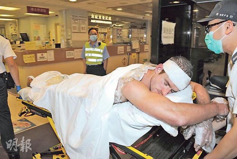 抽濕機短路火警中，兩名外籍男子救火時燒傷，其中一人背及雙手受傷，送院時需伏臥擔架上。（蔡方山攝）