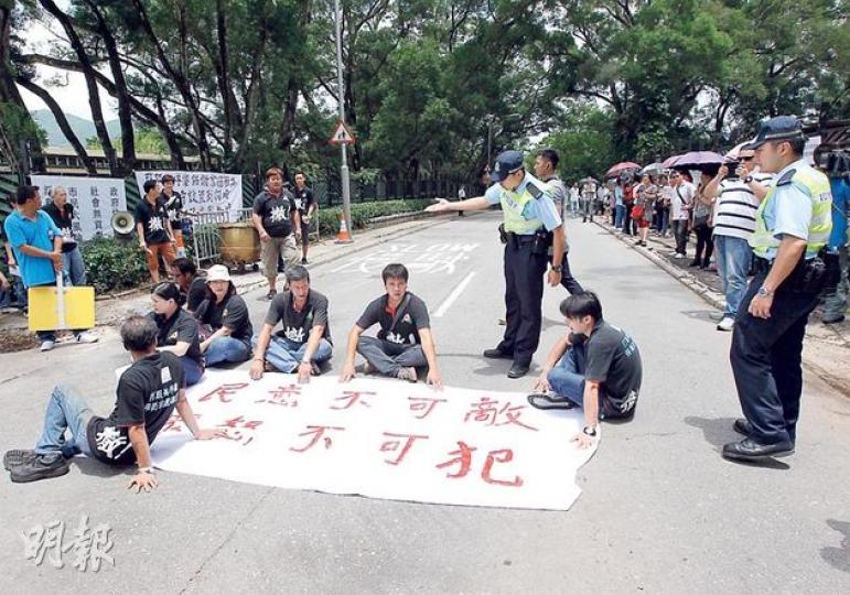 8名打鼓嶺坪輋保衛家園聯盟成員一度坐出馬路。聯盟代表李鳳眉說,若政府不回應村民的訴求,不排除會有更激烈的行動。(李紹昌攝) 8名打鼓嶺坪輋保衛家園聯盟成員一度坐出馬路。聯盟代表李鳳眉說,若政府不回應村民的訴求,不排除會有更激烈的行動。(李紹昌攝)