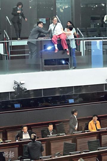 立法會工務小組昨審議在石鼓洲興建焚化爐的撥款申請,一名外籍女士於表決前突然在公眾席抗議,企圖跨越圍欄,終由保安員合力制服帶走。事後她批評特首梁振英違反選舉承諾,在全港最美麗的地方興建焚化爐,對此感到困擾。(林俊源攝)(明報製圖) 立法會工務小組昨審議在石鼓洲興建焚化爐的撥款申請,一名外籍女士於表決前突然在公眾席抗議,企圖跨越圍欄,終由保安員合力制服帶走。事後她批評特首梁振英違反選舉承諾,在全港最美麗的地方興建焚化爐,對此感到困擾。(林俊源攝)(明報製圖)