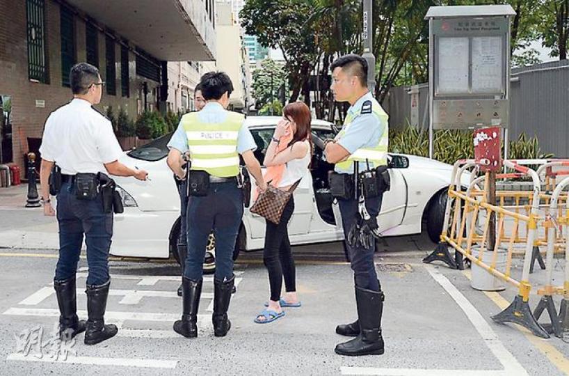 女乘客一度與男司機一起棄車逃跑，但她疑穿了一對尺碼過大的拖鞋，失足仆倒被截，最後涉嫌藏有攻擊性武器被捕。（蔡方山攝）