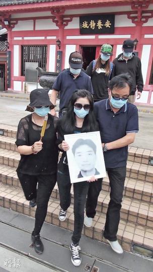 Liddy捧着父親李德仁的遺照,與母親(左)辦完超度儀式後離開富福山。(林智傑攝) Liddy捧着父親李德仁的遺照,與母親(左)辦完超度儀式後離開富福山。(林智傑攝)