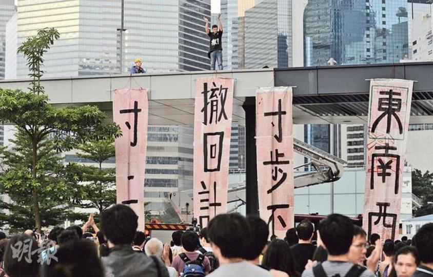 打鼓嶺坪輋保衛家園聯盟成員張貴財(圖上方)昨午5時,循中信大廈對出、政總附近地盤,爬上立法會簷篷頂,並沿着建構物一直走到立法會示威區上蓋。他在上蓋頂掛出寫有「撤回計劃」、「寸步不讓」等標語的直幡,返回地面後向警方自首。(余俊亮攝) 示威者協力把一條寫滿「反對」字樣的直幡舉起,交張貴財掛出。(余俊亮攝) 張貴財(黑衣者)被警員帶上警車,他接受傳媒訪問時表示,自己「犯法,但沒有犯罪」。(盧翊銘攝) 立法會餐廳昨午3時、財委會會議開始起停止服務,以免公眾因前往餐廳而有機會進入大堂。財委會晚飯時間,秘書 打鼓嶺坪輋保衛家園聯盟成員張貴財(圖上方)昨午5時,循中信大廈對出、政總附近地盤,爬上立法會簷篷頂,並沿着建構物一直走到立法會示威區上蓋。他在上蓋頂掛出寫有「撤回計劃」、「寸步不讓」等標語的直幡,返回地面後向警方自首。(余俊亮攝) 示威者協力把一條寫滿「反對」字樣的直幡舉起,交張貴財掛出。(余俊亮攝) 張貴財(黑衣者)被警員帶上警車,他接受傳媒訪問時表示,自己「犯法,但沒有犯罪」。(盧翊銘攝) 立法會餐廳昨午3時、財委會會議開始起停止服務,以免公眾因前往餐廳而有機會進入大堂。財委會晚飯時間,秘書