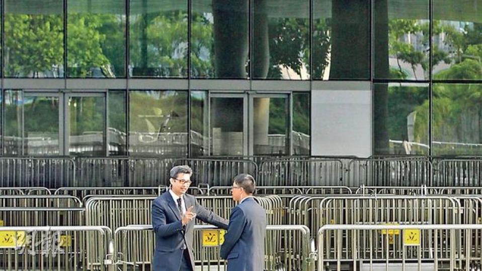 經歷上周五反東北發展團體衝擊後,立法會大樓外仍放置層層的鐵馬陣,而右上方一塊白板遮蓋的地方,是其中一道損壞的玻璃門。(李澤彤攝) 經歷上周五反東北發展團體衝擊後,立法會大樓外仍放置層層的鐵馬陣,而右上方一塊白板遮蓋的地方,是其中一道損壞的玻璃門。(李澤彤攝)