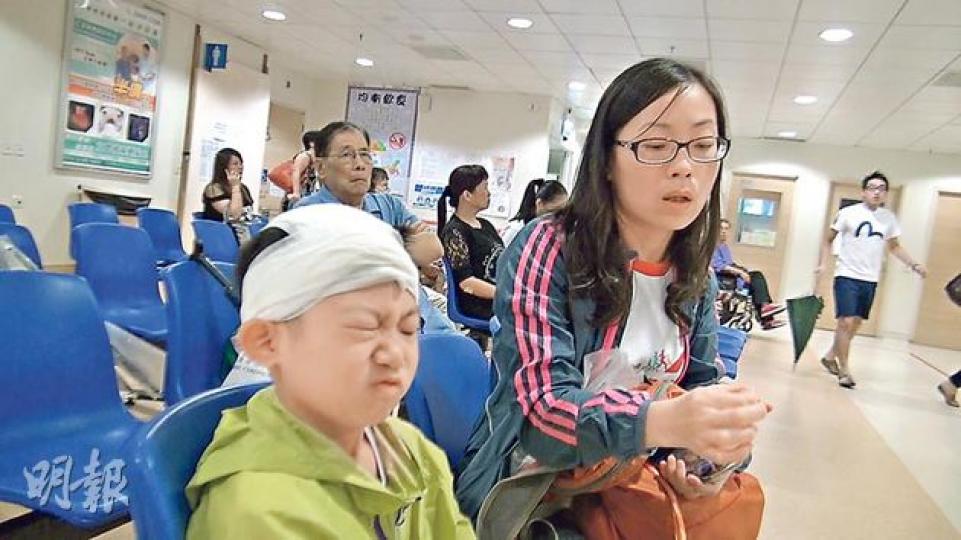 7歲男童(左)疑遭石屎擊中頭部,經包紮後由女親友陪同送院,不時表情多多。(林智傑攝) 7歲男童(左)疑遭石屎擊中頭部,經包紮後由女親友陪同送院,不時表情多多。(林智傑攝)