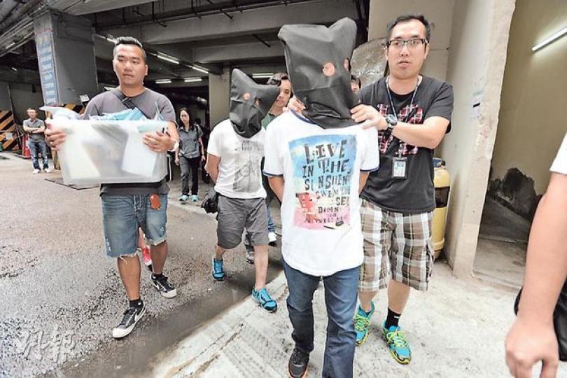 兩名被捕49歲賭檔男主持,經警方初步調查後,相信均有黑社會背景,被黑布蒙頭押返警署扣查。(衛永康攝) 兩名被捕49歲賭檔男主持,經警方初步調查後,相信均有黑社會背景,被黑布蒙頭押返警署扣查。(衛永康攝)