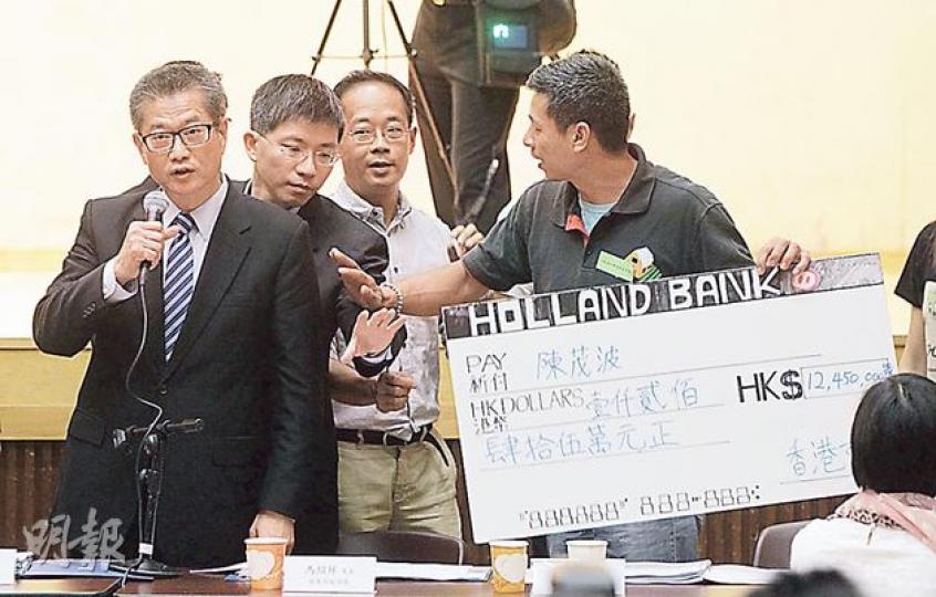 打鼓嶺及坪輋保衛家園聯盟成員張貴財(右一)昨日在會上向發展局長陳茂波(左一)送上一張道具支票,諷刺陳被揭在古洞囤地,日後可收回1200多萬元賠償。陳拒絕接受支票,指早前已清楚交代有關問題,呼籲大家不要再糾纏,沒完沒了的抹黑。(李澤彤攝)上水鄉委會主席侯志強(左)說,10多年前已經知道古洞要發展,認為今日很多反對計劃的人都不是原居民,又說新界人有「犧牲小我、完成大我」的精神,惟他希望政府提高安置賠償額至200萬元。(李澤彤攝)有自稱是馬屎埔村的婦人帶同3歲小孩到場,要求參與諮詢會被拒,10多名警員 打鼓嶺及坪輋保衛家園聯盟成員張貴財(右一)昨日在會上向發展局長陳茂波(左一)送上一張道具支票,諷刺陳被揭在古洞囤地,日後可收回1200多萬元賠償。陳拒絕接受支票,指早前已清楚交代有關問題,呼籲大家不要再糾纏,沒完沒了的抹黑。(李澤彤攝)上水鄉委會主席侯志強(左)說,10多年前已經知道古洞要發展,認為今日很多反對計劃的人都不是原居民,又說新界人有「犧牲小我、完成大我」的精神,惟他希望政府提高安置賠償額至200萬元。(李澤彤攝)有自稱是馬屎埔村的婦人帶同3歲小孩到場,要求參與諮詢會被拒,10多名警員