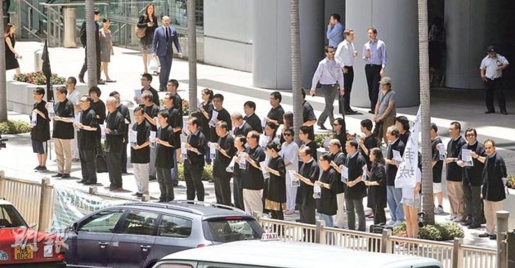 近50名民主派人士,包括「佔中」發起人戴耀廷、陳健民及朱耀明;公民黨主席余若薇、黨魁梁家傑及工黨主席何秀蘭等,昨身穿黑衣在中環匯豐總行附近默站一小時,抗議白皮書。他們手持寫有「當《基本法》已成為香港白皮書的時候,6月22-29日,你會做什麼」的單張,呼籲市民參與佔中投票及7.1大遊行,梁家傑亦呼籲參與今天的法律界遊行。有經過的司機豎起拇指讚好,亦有人指罵他們。(李紹昌攝) 近50名民主派人士,包括「佔中」發起人戴耀廷、陳健民及朱耀明;公民黨主席余若薇、黨魁梁家傑及工黨主席何秀蘭等,昨身穿黑衣在中環匯豐總行附近默站一小時,抗議白皮書。他們手持寫有「當《基本法》已成為香港白皮書的時候,6月22-29日,你會做什麼」的單張,呼籲市民參與佔中投票及7.1大遊行,梁家傑亦呼籲參與今天的法律界遊行。有經過的司機豎起拇指讚好,亦有人指罵他們。(李紹昌攝)