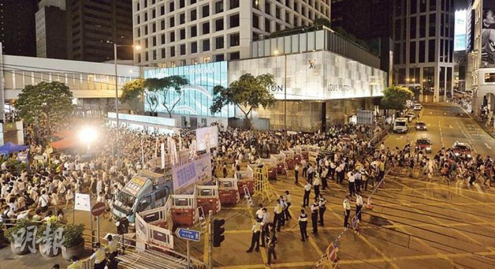 警方罕有地在中環置地廣場對出設置2米高水馬高牆,以防遊行人士衝往中區不同位置示威。圖為昨深夜大批集會人士聚集水馬一方,另一方警員則戒備。(鄧宗弘攝)昨晚8時許在銅鑼灣崇光百貨門外,逾百名警察在鐵馬陣後築起「人肉長城」,以防遊行人士衝破防線。(郭慶輝攝)昨午2時許,警車將大批載有警員裝備「彈袋」(turnout bag)運到中環遮打大廈旁,連同芝士餅等乾糧送入大廈內。據知這些彈袋內有頭盔、俗稱豬嘴的防毒面罩及衣物。過去七一遊行甚少見警方動用這些裝備,而2005年世貿部長級會議韓農示威中則見警方廣泛 警方罕有地在中環置地廣場對出設置2米高水馬高牆,以防遊行人士衝往中區不同位置示威。圖為昨深夜大批集會人士聚集水馬一方,另一方警員則戒備。(鄧宗弘攝)昨晚8時許在銅鑼灣崇光百貨門外,逾百名警察在鐵馬陣後築起「人肉長城」,以防遊行人士衝破防線。(郭慶輝攝)昨午2時許,警車將大批載有警員裝備「彈袋」(turnout bag)運到中環遮打大廈旁,連同芝士餅等乾糧送入大廈內。據知這些彈袋內有頭盔、俗稱豬嘴的防毒面罩及衣物。過去七一遊行甚少見警方動用這些裝備,而2005年世貿部長級會議韓農示威中則見警方廣泛