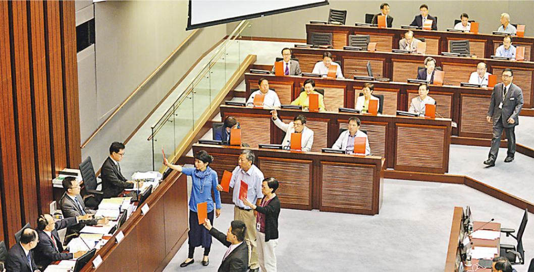 立法會財務委員會會議，民主派議員不滿吳亮星（左二）主持會議作風，齊如足球球證般向吳亮星出示「紅牌」，促其「離場」。吳亮星其後裁定，5名議員屬行為不檢，判罰離場。（盧翊銘攝）