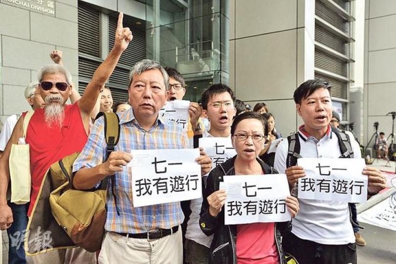 警方日前拘捕5名七一遊行主辦者。當日有參與遊行的工黨成員包括立法會議員李卓人（前排左一）及何秀蘭（前排左二）等，昨早到灣仔警察總部投案。（鄧宗弘攝）民主黨9名成員昨早到警察總部向警方投案，指自己有違反七一遊行「不反對通知書」，他們展示的是警方發出的報案號碼紙。（鄧宗弘攝）