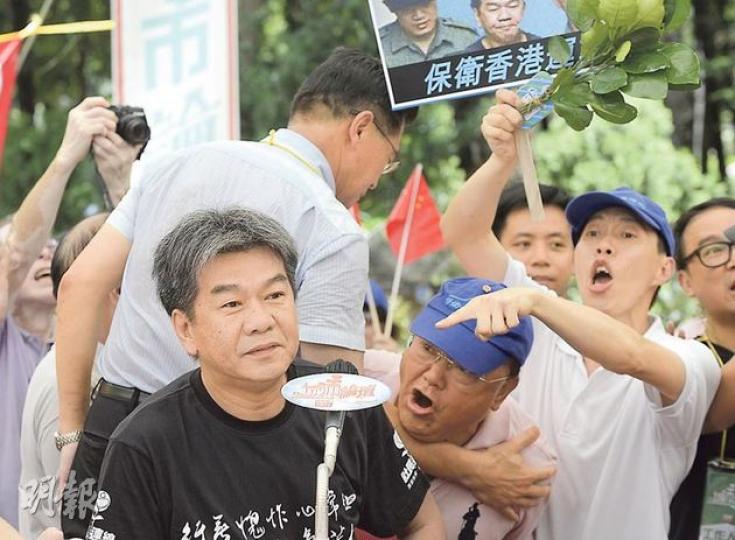保衛香港運動召集人傅振中(右舉牌者)噚日揸住碌柚葉,聯同多名成員去《城市論壇》狙擊梁國雄(左),話佢係「監躉」。長毛之後同Emily講,唔知仲以為佢哋有「坐監情意結」。(余俊亮攝) 保衛香港運動召集人傅振中(右舉牌者)噚日揸住碌柚葉,聯同多名成員去《城市論壇》狙擊梁國雄(左),話佢係「監躉」。長毛之後同Emily講,唔知仲以為佢哋有「坐監情意結」。(余俊亮攝)