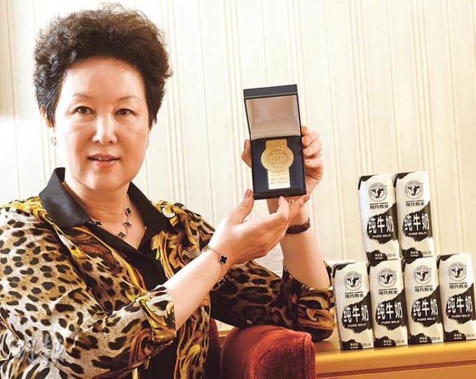 高麗娜展示現代牧業自家品牌「常溫奶」獲得的法國波爾多Monde Selection食品類金獎，這亦是對產品品質的國際肯定。（劉焌陶攝）