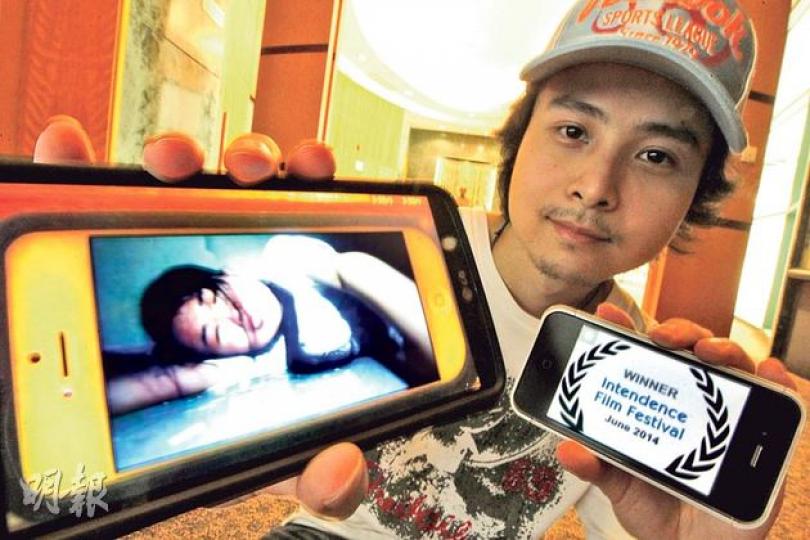 自稱異類的新晉導演何冠寰(圖),去年把電影宣傳片(左手機)放上YouTube,惹來警員介入調查,但作品令他在兩個美國影展中獲獎。 (李紹昌攝) 自稱異類的新晉導演何冠寰(圖),去年把電影宣傳片(左手機)放上YouTube,惹來警員介入調查,但作品令他在兩個美國影展中獲獎。 (李紹昌攝)