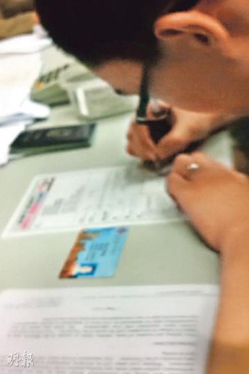 本報記者昨日到中聯辦在信德中心辦理「留學證明」的辦公室,目擊有職員向申請「留學證明」的學生遞上「反佔中」記名表格,格式與「保普選反佔中大聯盟」早前向記者展示的表格相同。(明報記者攝) 本報記者昨日到中聯辦在信德中心辦理「留學證明」的辦公室,目擊有職員向申請「留學證明」的學生遞上「反佔中」記名表格,格式與「保普選反佔中大聯盟」早前向記者展示的表格相同。(明報記者攝)