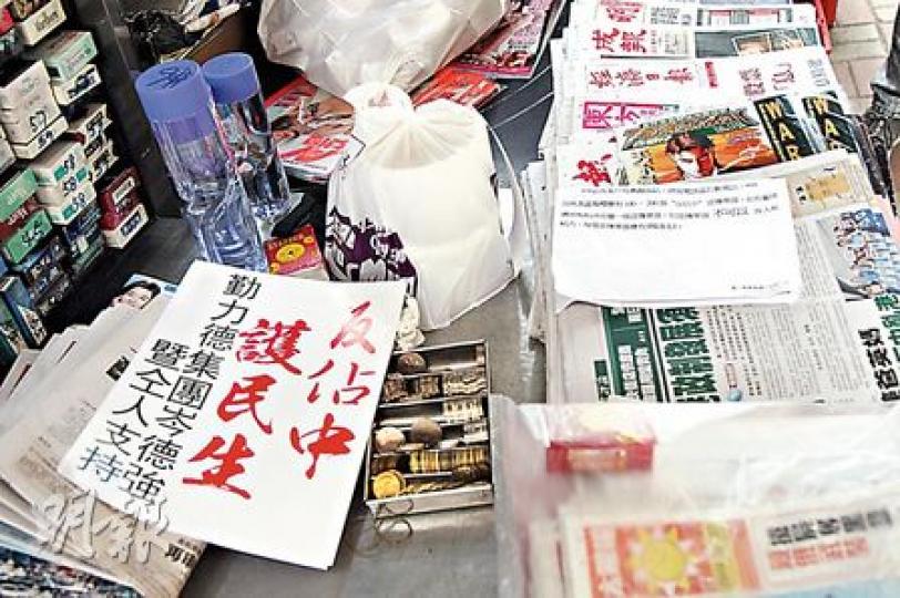 有中環報販擺出「反佔中」單張畀顧客任攞，右方嘅紙張，聲稱係勤力德集團畀報販嘅通知，內容提及派單張有津貼，每張「反佔中」單張有3毫子津貼。（林俊源攝）