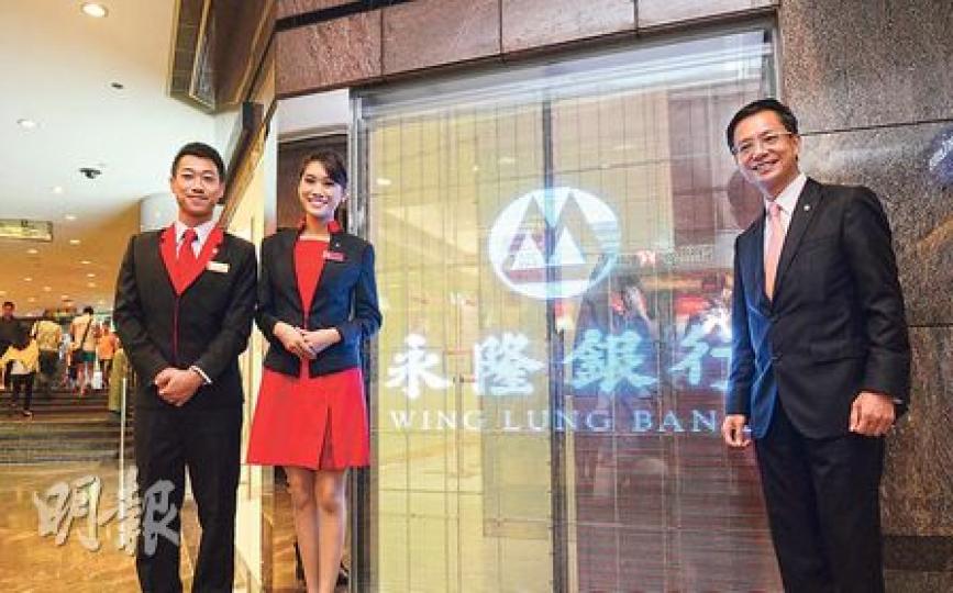 灣仔會展永隆分行最近裝嘅呢塊玻璃屏幕,永隆助理總經理及零售銀行主管鍾少權(右)話叫做「e-glass」,好有cyber feel;而左邊兩位職員亦展示永隆新制服,給客戶帶來新鮮感。(陳淑安攝) 灣仔會展永隆分行最近裝嘅呢塊玻璃屏幕,永隆助理總經理及零售銀行主管鍾少權(右)話叫做「e-glass」,好有cyber feel;而左邊兩位職員亦展示永隆新制服,給客戶帶來新鮮感。(陳淑安攝)