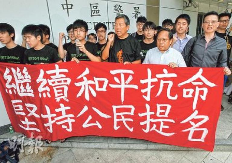 「佔中預演」11名被捕人包括學聯周永康(左三)、工黨李卓人(右三)、民主黨何俊仁(右二)昨早到中區警署報到,但拒絕保釋,其後警方「無條件釋放」各人,但保留檢控權利。(李紹昌攝) 「佔中預演」11名被捕人包括學聯周永康(左三)、工黨李卓人(右三)、民主黨何俊仁(右二)昨早到中區警署報到,但拒絕保釋,其後警方「無條件釋放」各人,但保留檢控權利。(李紹昌攝)