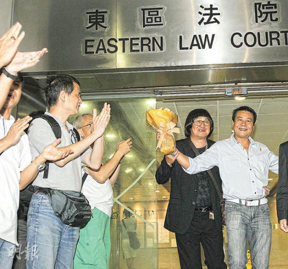 在法院門外掌摑「香港人優先」成員招顯聰的被告陳岳賢(右一),昨被判處社會服務令,他在支持者掌聲中,手持花束離開法院。(李紹昌攝) 在法院門外掌摑「香港人優先」成員招顯聰的被告陳岳賢(右一),昨被判處社會服務令,他在支持者掌聲中,手持花束離開法院。(李紹昌攝)