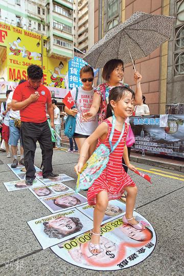 昨日遊行路線中,有團體在灣仔修頓球場一帶地下貼上印有「黑金遊戲」的跳飛機,上印有壹傳媒集團主席黎智英、曾收取其捐款者的相片,包括前政務司長陳方安生等。(林俊源攝)基本法委員會委員兼港區人大代表譚惠珠(右一)昨早聯同行政會議成員羅范椒芬(右三),一同到中環獻花,但二人未有參加大遊行。(李紹昌攝) 昨日遊行路線中,有團體在灣仔修頓球場一帶地下貼上印有「黑金遊戲」的跳飛機,上印有壹傳媒集團主席黎智英、曾收取其捐款者的相片,包括前政務司長陳方安生等。(林俊源攝)基本法委員會委員兼港區人大代表譚惠珠(右一)昨早聯同行政會議成員羅范椒芬(右三),一同到中環獻花,但二人未有參加大遊行。(李紹昌攝)