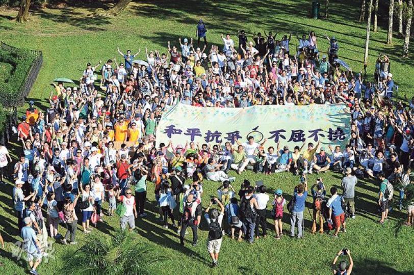 「和平佔中」昨舉行「民主登高」,一眾參加者由香港公園步行約兩小時抵達山頂公園後,在「和平抗爭、不屈不撓」大型橫額上打手印,並留影紀念。(葉家豪攝) 「和平佔中」昨舉行「民主登高」,一眾參加者由香港公園步行約兩小時抵達山頂公園後,在「和平抗爭、不屈不撓」大型橫額上打手印,並留影紀念。(葉家豪攝)