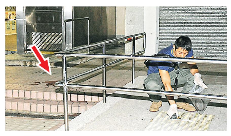 女子墮樓身亡後,在地上遺下一灘血迹(箭嘴示),探員事後檢走死者的物品返署調查。(蔡方山攝) 女子墮樓身亡後,在地上遺下一灘血迹(箭嘴示),探員事後檢走死者的物品返署調查。(蔡方山攝)