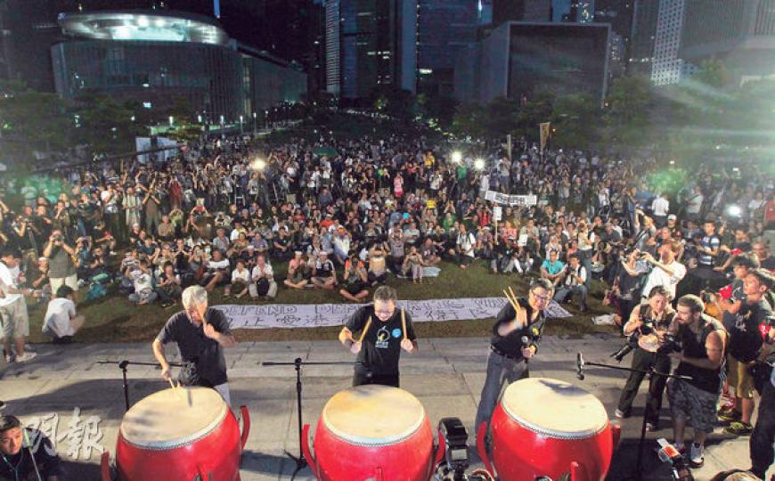 人大昨午通過特首普選框架後,佔中三子及多個泛民政黨昨晚隨即於添馬公園舉行集會,其間大會呼籲市民舉起手機及響起手機,象徵市民要向中央發聲。參與的市民坐滿公園草地,大會稱有5000人參與,警方則指高峰時有2640人。佔中三子朱耀明(左起)、戴耀廷及陳健民則擊鼓警示,以示對人大決定的不滿。(李澤彤攝)人大常委會通過政改決定後,特首梁振英(前)昨日率領全體問責官員、行政會議成員會見傳媒,顯得神態自若,一直面帶笑容,並自行點選傳媒發問,與身旁一眾官員和行會成員木無表情的樣子,形成強烈對比。(李澤彤攝) 人大昨午通過特首普選框架後,佔中三子及多個泛民政黨昨晚隨即於添馬公園舉行集會,其間大會呼籲市民舉起手機及響起手機,象徵市民要向中央發聲。參與的市民坐滿公園草地,大會稱有5000人參與,警方則指高峰時有2640人。佔中三子朱耀明(左起)、戴耀廷及陳健民則擊鼓警示,以示對人大決定的不滿。(李澤彤攝)人大常委會通過政改決定後,特首梁振英(前)昨日率領全體問責官員、行政會議成員會見傳媒,顯得神態自若,一直面帶笑容,並自行點選傳媒發問,與身旁一眾官員和行會成員木無表情的樣子,形成強烈對比。(李澤彤攝)