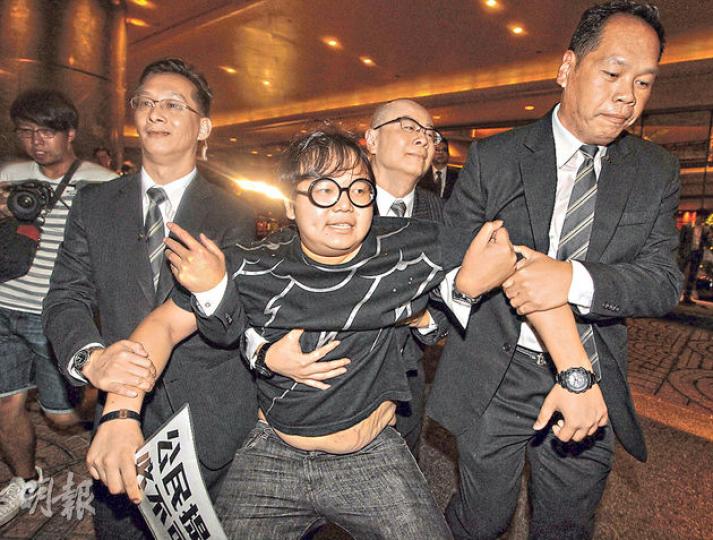 學民思潮成員林淳軒昨凌晨零時15分手持印有「公民提名必不可少」紙張，企圖向即將抵埗的李飛表達訴求，被數名君悅酒店保安強行抬至酒店門外。（李澤彤攝）