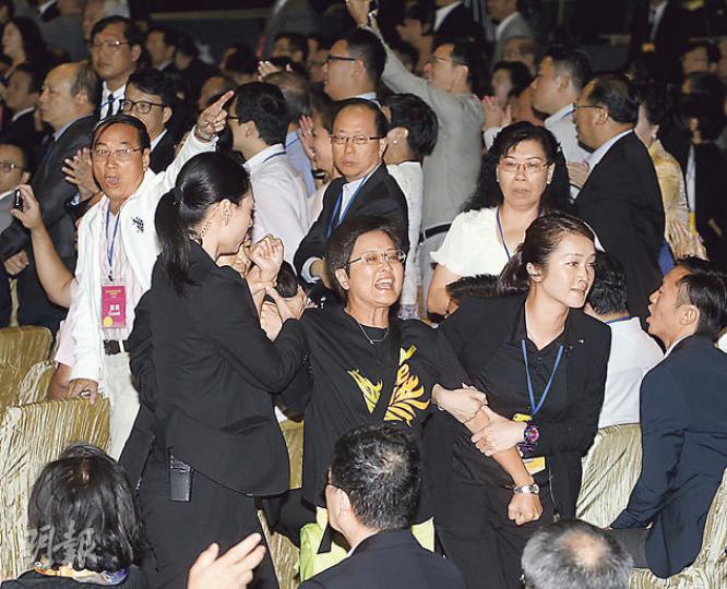 民主黨立法會議員黃碧雲(中)昨在政改簡介會上抗議,被工作人員帶離現場,有建制派人士拍掌叫好。(李紹昌攝) 民主黨立法會議員黃碧雲(中)昨在政改簡介會上抗議,被工作人員帶離現場,有建制派人士拍掌叫好。(李紹昌攝)