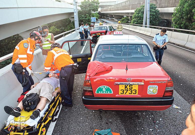 在的士3車相撞意外中,其中一名司機撞車後報稱感到頭痛,救援人員用擔架牀將他送院。(蔡方山攝) 在的士3車相撞意外中,其中一名司機撞車後報稱感到頭痛,救援人員用擔架牀將他送院。(蔡方山攝)