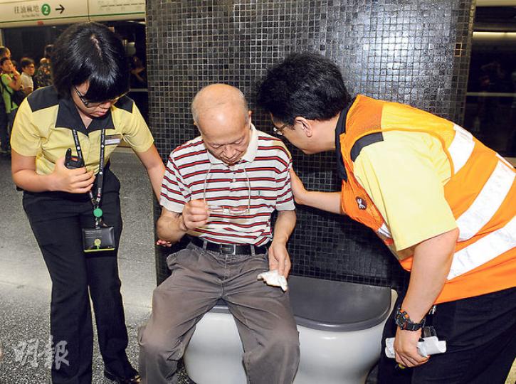 鑽石山站故障期間，列車一度擁擠，一名長者（中）在調景嶺上車準備往九龍塘，到鑽石山站不支暈倒，要中途落車由港鐵職員扶往休息室等候治理。（蔡方山攝）