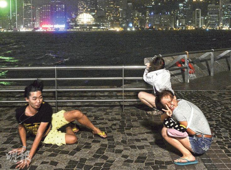 8號風球下,數名年輕人昨晚專程到尖沙嘴海旁吹風,感受「海鷗」的威力。(余俊亮攝) 8號風球下,數名年輕人昨晚專程到尖沙嘴海旁吹風,感受「海鷗」的威力。(余俊亮攝)
