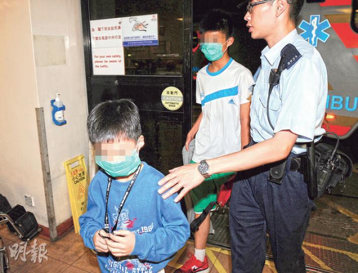 在葵涌梨木樹二邨被留在家的7歲及12歲男童,由警員帶到醫院接受檢驗。 (蔡方山攝) 在葵涌梨木樹二邨被留在家的7歲及12歲男童,由警員帶到醫院接受檢驗。 (蔡方山攝)