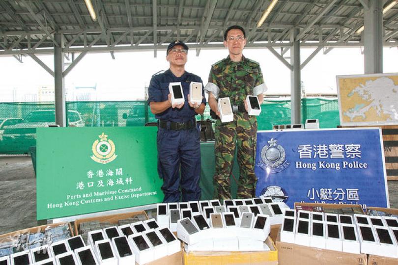 海關港口及海域科總指揮官李德信(左)及水警小艇分區警司梁宗定展示緝獲的走私貨品,當中包括138部iPhone 6手機。 (伍浦鋒攝) 海關港口及海域科總指揮官李德信(左)及水警小艇分區警司梁宗定展示緝獲的走私貨品,當中包括138部iPhone 6手機。 (伍浦鋒攝)