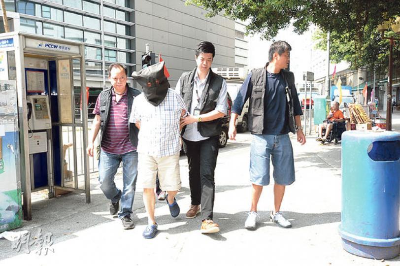 涉嫌潑腐液的六旬男子黑布蒙頭,由重案組探員押至德田商場重組案情。(衛永康攝) 涉嫌潑腐液的六旬男子黑布蒙頭,由重案組探員押至德田商場重組案情。(衛永康攝)