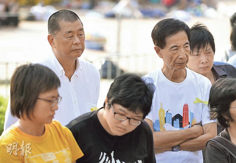 壹傳媒主席黎智英(後排左白衣者)及民主黨創黨主席李柱銘(後排右白衣者)昨晨到政府總部出席祈禱會,神情凝重。黎智英及後中兩枚催淚彈。(余俊亮攝) 壹傳媒主席黎智英(後排左白衣者)及民主黨創黨主席李柱銘(後排右白衣者)昨晨到政府總部出席祈禱會,神情凝重。黎智英及後中兩枚催淚彈。(余俊亮攝)