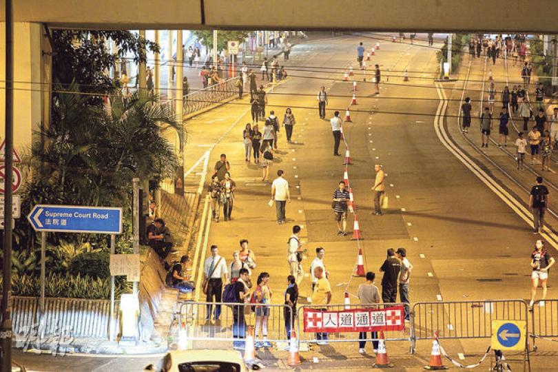 和平佔中宣布在「佔領區」設立「人道通道」,容許救護車及大會運送物資的車輛出入。圖為大會人員晚上在金鐘道近法院道交界的西行線擺放雪糕筒、鐵馬和標記,劃出人道通道範圍。(郭慶輝攝) 和平佔中宣布在「佔領區」設立「人道通道」,容許救護車及大會運送物資的車輛出入。圖為大會人員晚上在金鐘道近法院道交界的西行線擺放雪糕筒、鐵馬和標記,劃出人道通道範圍。(郭慶輝攝)