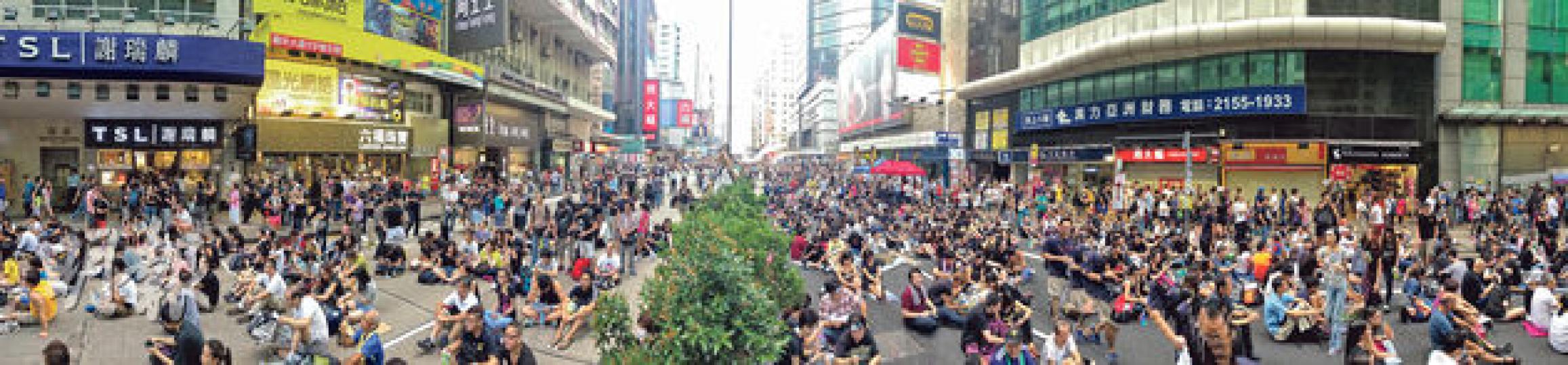 旺角昨續有大批市民聚集,區內部分零售點稱生意受影響,以金舖或表行為主。黃金周開始,彌敦道被「佔領」,道路兩旁金舖各有選擇,圖左方的謝瑞麟、六福珠寶及周生生一度關門,昨重開營業,但圖右方的周大福則落閘不做生意。不過現場所見,集會者大都安坐馬路,行人路未見阻塞,無礙商舖出入口;謝瑞麟旺角分店職員回覆本報稱,金舖在周一及周二曾暫停營業,見昨早集會人流減少遂重開,但營業時間都是「遲開早收」。(郭慶輝攝) 旺角昨續有大批市民聚集,區內部分零售點稱生意受影響,以金舖或表行為主。黃金周開始,彌敦道被「佔領」,道路兩旁金舖各有選擇,圖左方的謝瑞麟、六福珠寶及周生生一度關門,昨重開營業,但圖右方的周大福則落閘不做生意。不過現場所見,集會者大都安坐馬路,行人路未見阻塞,無礙商舖出入口;謝瑞麟旺角分店職員回覆本報稱,金舖在周一及周二曾暫停營業,見昨早集會人流減少遂重開,但營業時間都是「遲開早收」。(郭慶輝攝)