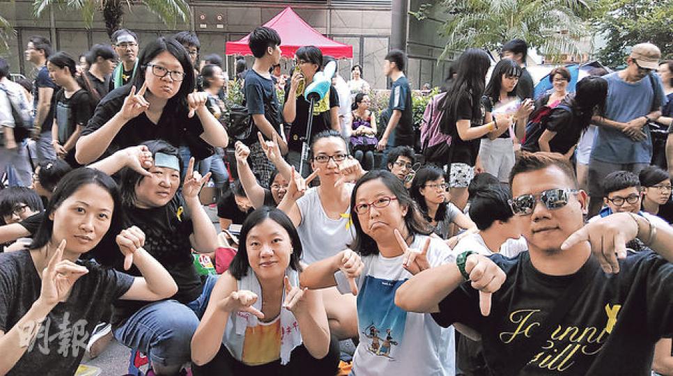 身穿黃衣、肩披毛巾的手語翻譯員陳意軒(前排左三)表示,自從民間以「狼」比喻特首梁振英後,聾人社區亦以「狼」手勢來表示梁振英,集會時當大眾高叫口號,聾人都會一手做出狼手勢,另一手做出拇指向下,以表示「梁振英下台」。(黎芷欣攝) 身穿黃衣、肩披毛巾的手語翻譯員陳意軒(前排左三)表示,自從民間以「狼」比喻特首梁振英後,聾人社區亦以「狼」手勢來表示梁振英,集會時當大眾高叫口號,聾人都會一手做出狼手勢,另一手做出拇指向下,以表示「梁振英下台」。(黎芷欣攝)