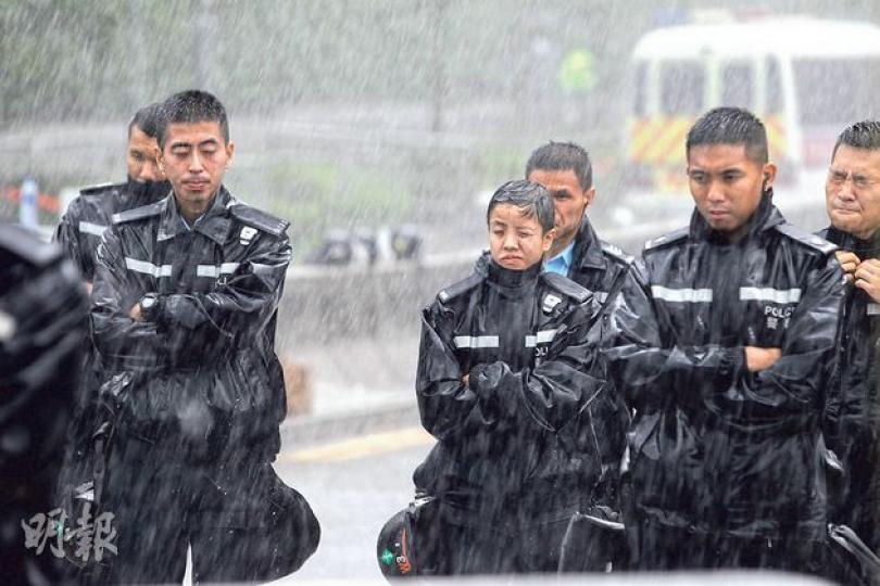 大量配有防暴裝備的警務人員昨於灣仔金鐘一帶駐守,昨遇突如其來的傾盤大雨,被淋至全身濕透。各警員在淋雨一段時間後戴上防暴頭盔,免頭部不停被雨打。(李紹昌攝) 大量配有防暴裝備的警務人員昨於灣仔金鐘一帶駐守,昨遇突如其來的傾盤大雨,被淋至全身濕透。各警員在淋雨一段時間後戴上防暴頭盔,免頭部不停被雨打。(李紹昌攝)