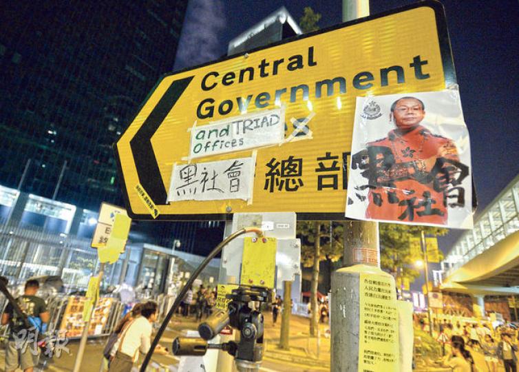 旺角有佔領者被襲擊,警方執法備受非議,被指縱容黑社會,「政府總部」的指示牌被人貼上「黑社會」3字,變成「黑社會總部」,並將警務處長曾偉雄的相片配以黑社會字眼。(盧翊銘攝)在特首辦外的集會人士早前曾阻止警察餐車入內,亦有人於特首辦外的大閘貼上寫有「不准餵食、政總動物園」的標語,有前線警員看到感到十分侮辱。(盧翊銘攝) 旺角有佔領者被襲擊,警方執法備受非議,被指縱容黑社會,「政府總部」的指示牌被人貼上「黑社會」3字,變成「黑社會總部」,並將警務處長曾偉雄的相片配以黑社會字眼。(盧翊銘攝)在特首辦外的集會人士早前曾阻止警察餐車入內,亦有人於特首辦外的大閘貼上寫有「不准餵食、政總動物園」的標語,有前線警員看到感到十分侮辱。(盧翊銘攝)