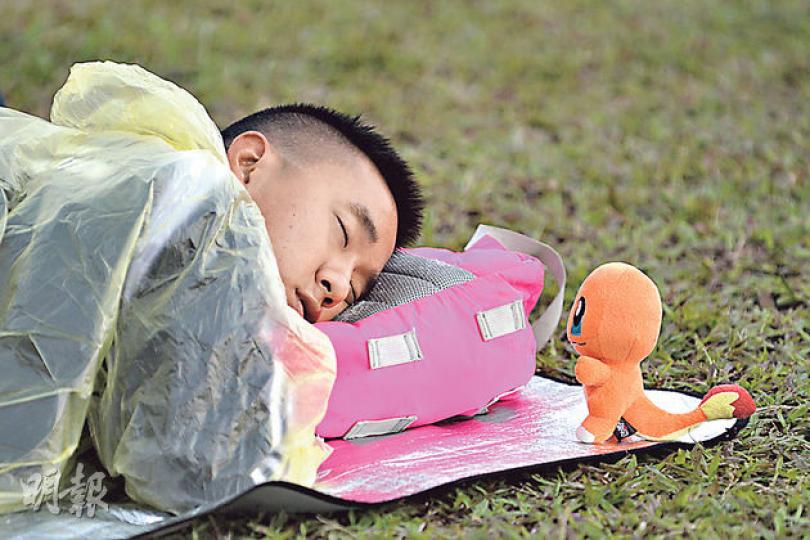 佔領行動持續逾一星期,有人會喺金鐘政府總部旁嘅添馬公園席地而睡,而呢位仁兄更「不愁寂寞」,因為有小火龍公仔做夢伴。(盧翊銘攝) 佔領行動持續逾一星期,有人會喺金鐘政府總部旁嘅添馬公園席地而睡,而呢位仁兄更「不愁寂寞」,因為有小火龍公仔做夢伴。(盧翊銘攝)